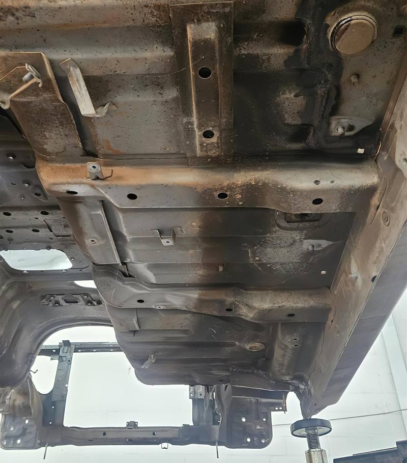Vehicle underbody half cleaned by dry ice blasting — clear line between dirty and clean metal